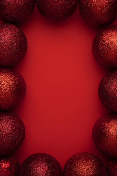 Χριστούγεννα κάθετη σύνθεση των κόκκινων στολίδια μπάλα στολίδια. Χριστουγεννιάτικα στολίδια σε κόκκινο φόντο. Επίπεδο lay, πάνω όψη, αντιγραφή χώρου - Φωτογραφία, εικόνα