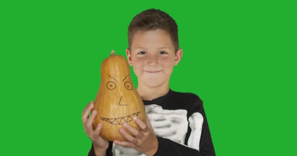Mały chłopiec w kostiumie z pumkin uśmiecha się na Halloween party przeciwko chroma key zielony ekran tło. - Materiał filmowy, wideo
