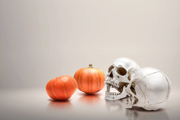 Pumpkin and human skull - Φωτογραφία, εικόνα