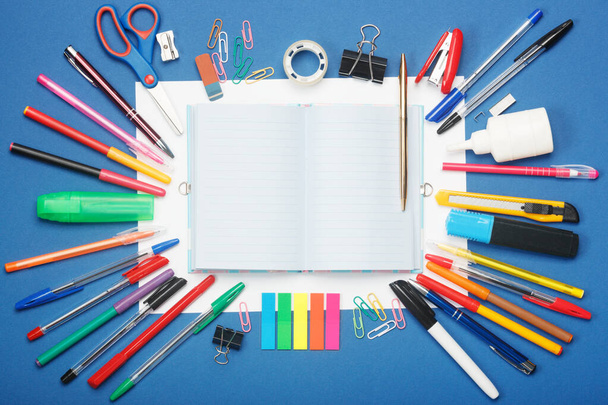 Stationery and blank notebook on blue background. Education concept with copy space for your ideas. - Фото, изображение
