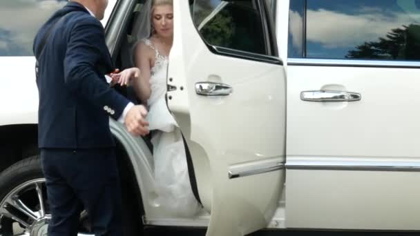 Bräutigam hilft Braut aus Hochzeitsauto - Filmmaterial, Video