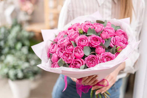 Montones de brotes Rosas de color rosa fucsia. Ramo en mano de mujer. el trabajo de la floristería en una floristería Concepto de floristería
 - Foto, Imagen