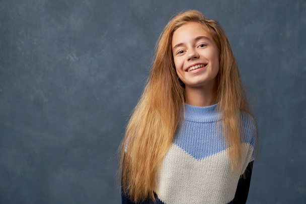Teenage girl blonde in warm sweater isolated wall - Foto, immagini
