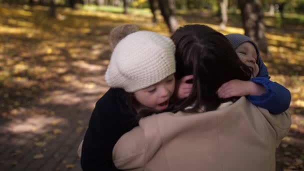Счастливые маленькие дети обнимаются с матерью в парке
 - Кадры, видео