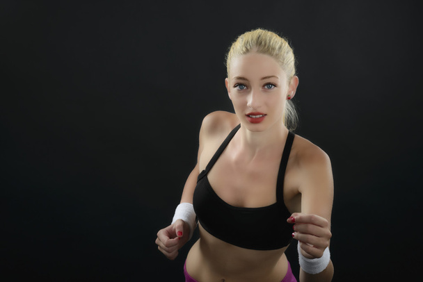 Portrait of a sexy fitness woman isolated on black - Photo, Image