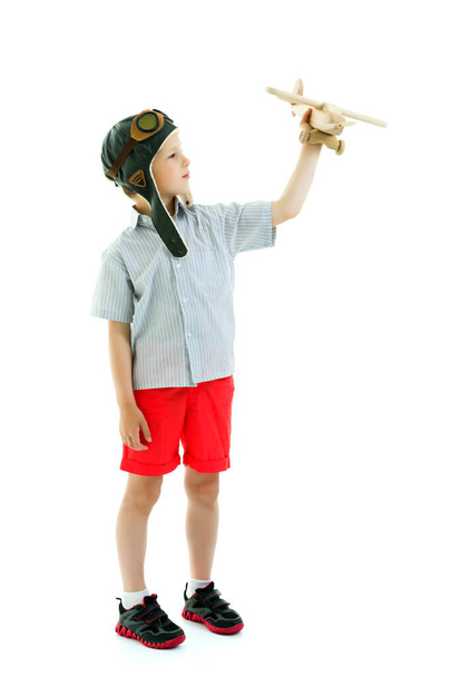 Мальчик играет с деревянным самолетом - Фото, изображение