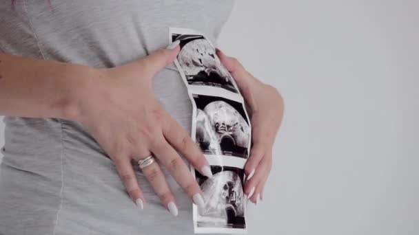 Mujer embarazada morena en poses de camisa gris. Madre con ultrasonido Scan
. - Metraje, vídeo