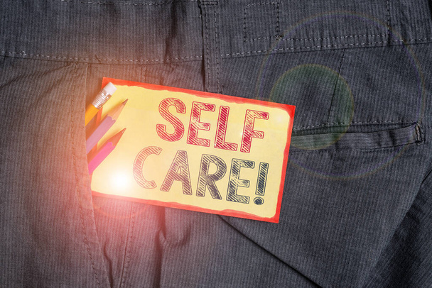 Conceptual hand writing showing Self Care. Business photo showcasing practice of taking action preserve or improve ones own health Writing equipment and yellow notepaper in pocket of trousers. - Photo, Image