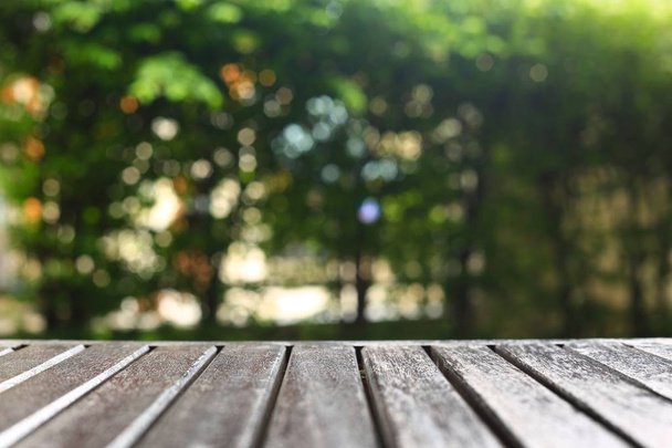 wooden floor background for products placement copy space. wood table in a garden. forest bokeh light background. warm tone image - Photo, Image