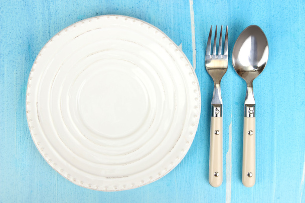 Plate and cutlery on wooden table close-up - Фото, изображение