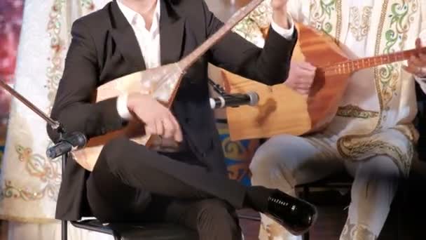 Kazahsztán zenéje. A férfi zenészek dombra-t játszanak. Kazah nemzeti hangszerek és ruhák. Koncertelőadás. - Felvétel, videó