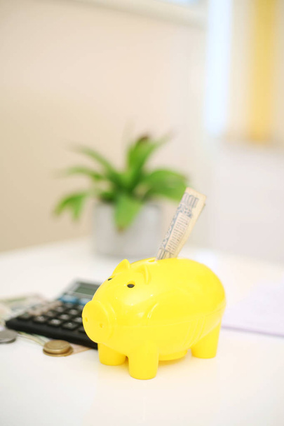  Imagen de una persona depositando dinero en una alcancía amarilla. Aislado sobre fondo
. - Foto, imagen
