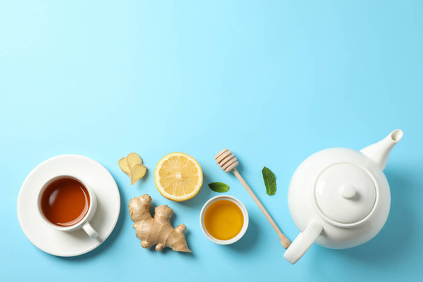 Płaski lay. Filiżanka herbaty, czajniczek, cytryna, imbir, mięta, miód i DIP - Zdjęcie, obraz