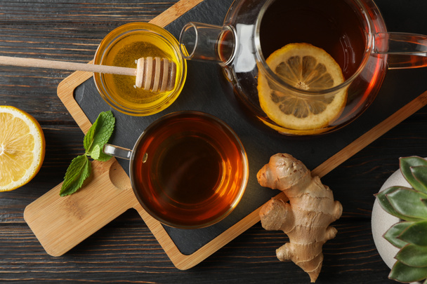 Τσάι, μέντα, μέλι, τζίντζερ και τσαγιέρα σε ξύλινο φόντο, - Φωτογραφία, εικόνα