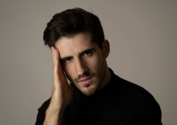 Portrait of young handsome manly man looking sexy and sensual with beautiful dark ayes and hair. Studio shot of spanish masculine model posing . In fashion, natural beauty, modeling and lifestyle. - 写真・画像