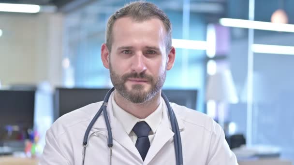 Portret wesołego młodego lekarza pokazującego kciuki w górę - Materiał filmowy, wideo