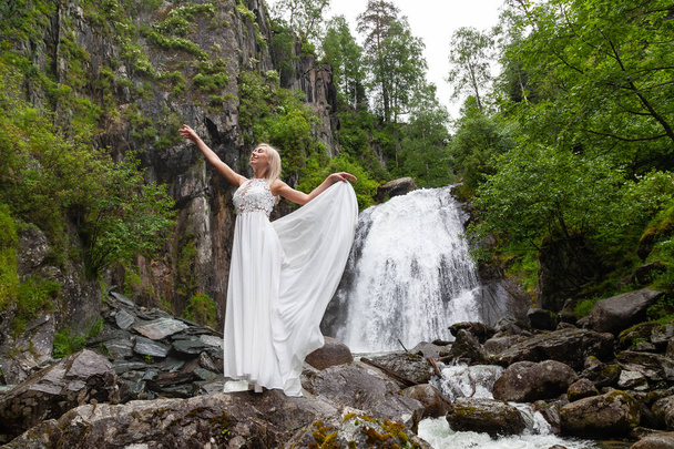A young blonde girl in an elegant pose pulls up a boudoir dress  - Fotografie, Obrázek