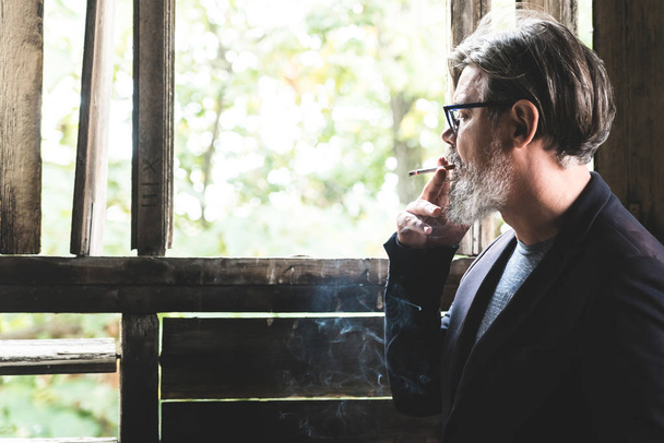 Man smoking cigarette and watching from old hall - Foto, Imagen