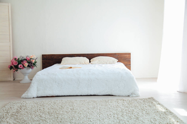 Fehér hálószoba világos belső terek, ágy és virágok - Fotó, kép