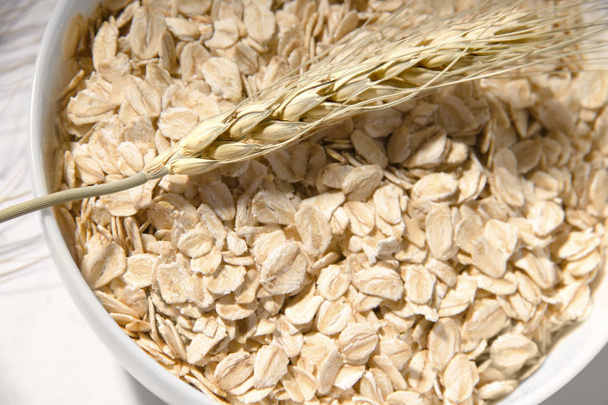 ucho pšenice detailní záběr na pozadí ovesné kaše v talíři. přirozená výživa - Fotografie, Obrázek