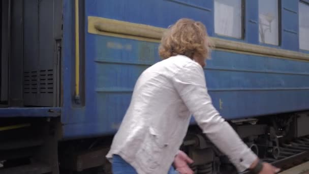 Setkání milujících lidí, šťastná mladá žena objímá muže a směje se u vagónu na nádraží po oddělení - Záběry, video