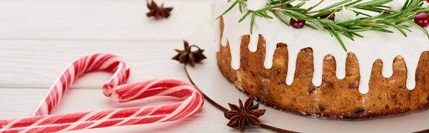 christmas pie with icing on white wooden table with candy canes and anise star seeds - Foto, Imagen