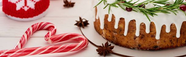 tarta de Navidad con glaseado en mesa de madera blanca con copa, bastones de caramelo y ramas de abeto
 - Foto, Imagen