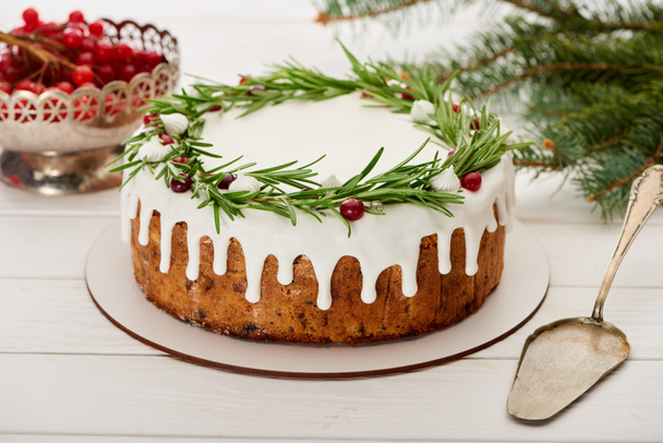 vánoční koláč a vibrační bobule na bílém dřevěném stole se smrkovými větvemi - Fotografie, Obrázek