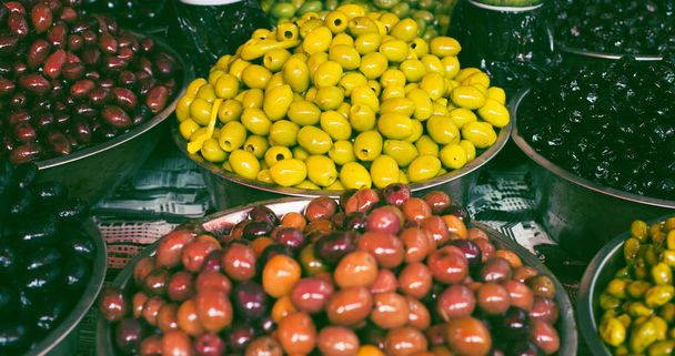 Olives in bowls at the market for sale. Traditional mediterranea - 写真・画像