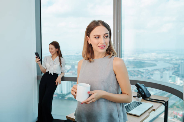 Geschäftsfrauen im modernen Büro mit Teetassen - Foto, Bild
