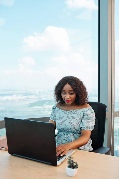 Genç bayan girişimci ofis masasında oturuyor, dizüstü bilgisayarda çalışıyor ve e-postaları okuyor.  - Fotoğraf, Görsel