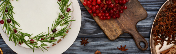 top view of christmas pie, anise star seeds and viburnum berries on dark wooden table  - Фото, зображення