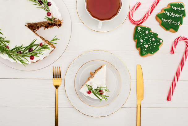 top view of christmas pie, tea, cookies and candy canes on white wooden table - Fotografie, Obrázek