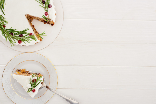 白い木製のテーブルの上にローズマリーとクランベリーと甘いクリスマスパイのトップビュー  - 写真・画像