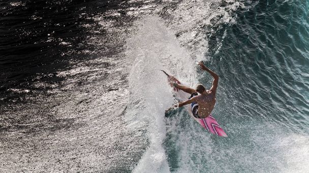 Surfista realizando maniobra de recorte en el labio de la ola azul en Padang Padang, Bali, Indonesia
 - Foto, Imagen