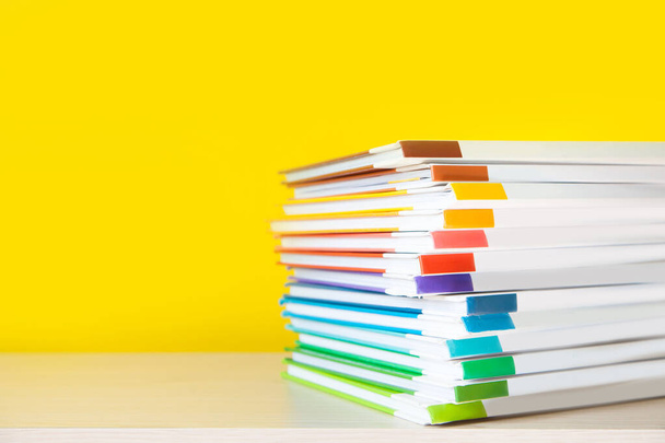 Stack of colorful books on color background.  - 写真・画像