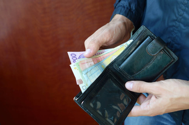 Nahaufnahme männliche Hände öffneten die Brieftasche oder Geldbörse mit ukrainischem Geld Währung Griwna - Foto, Bild