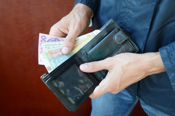 Close up mani maschili aperto il portafoglio o borsa con moneta ucraina grivna
 - Foto, immagini