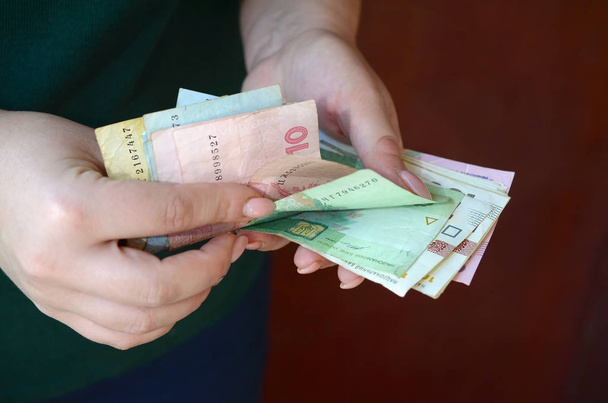 Kobiece ręce liczą dużą ilość ukraińskich pieniędzy podczas okresu pensji na Ukrainie - Zdjęcie, obraz