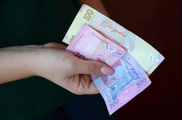 Női kéz számít nagy mennyiségű ukrán pénzt a fizetési időszak alatt Ukrajnában - Fotó, kép