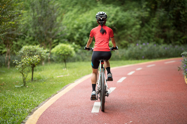 Ciclista fêmea montando bicicleta de montanha ao ar livre na floresta - Foto, Imagem