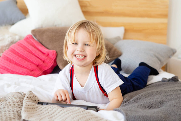 Smiling child using tablet at home. - Foto, Imagem