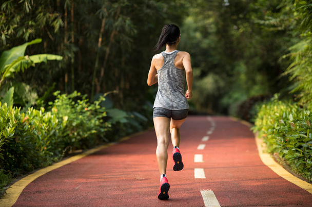 Healthy fitness female runner jogging outdoors on park trail. - Foto, Imagem