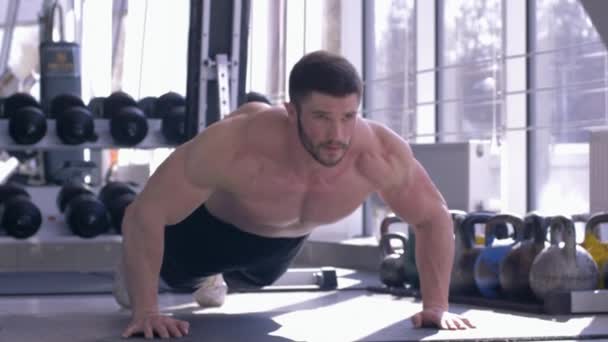 sports training, muscular sportsman with beautiful athletic body does pushups during power workout at fitness club - Footage, Video