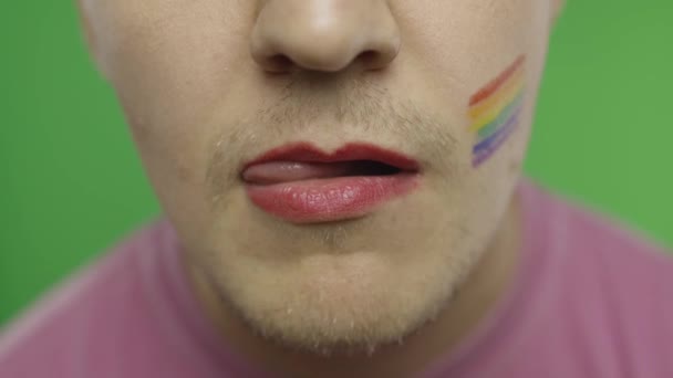 描かれた唇を持つひげを生やした男はそれらを性的になめる。LGBTコミュニティ。性転換 - 映像、動画