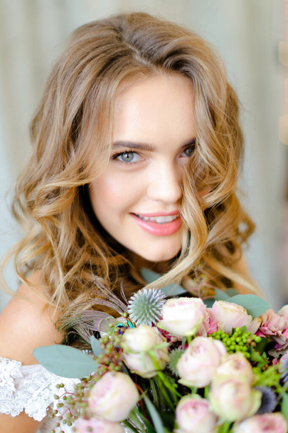 Close up portrait of young bride with bouquet at photo studio. - Photo, image
