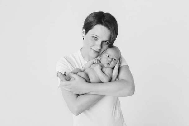 photo in black and white: the mother holds her son in her arms. Family portrait: a woman with a child. Health care concept: healthy family - Fotografie, Obrázek