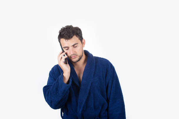 Portré álmos fiatalember piszkos haj, visel kék fürdőköpeny, sp - Fotó, kép