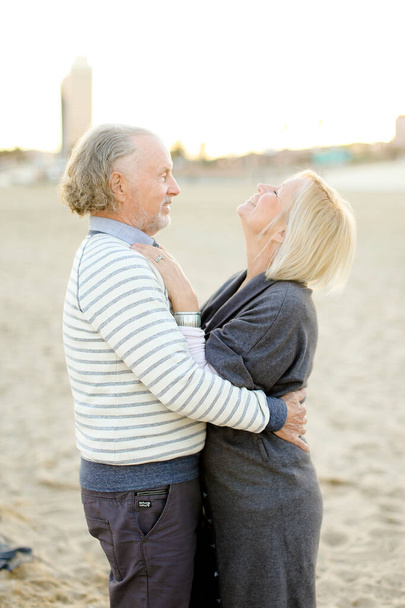 Senior europeo marido abrazando esposa en arena playa fondo
. - Foto, imagen