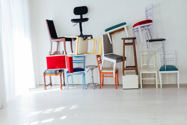 many multicolored chairs stand in the white room - Foto, afbeelding
